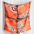 Dettaglio di sciarpa arancione con motivi geometrici e trama di tessuto leggero - Patchwork Geometrico Arancione Nero Bianco