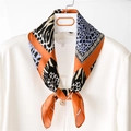 Elegante pañuelo de seda con estampado animal y cadenas en blusa blanca con perla - Naranja