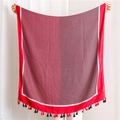 Dettaglio di sciarpa rossa con motivo a rombi e lunghe nappe di frangia bicolore - Rosso