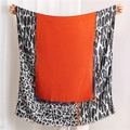 Detail of leopard print scarf with orange center, chain patterns, and frayed edges - Orange