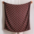 Detail view of coffee brown shawl with red and white geometric V-pattern silk texture - Black and Gray