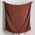 Detail of red-brown shawl with blue geometric abstract patterns in light fabric - Rust red