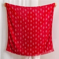 Detail of red geometric diamond pattern scarf with soft frayed edges being held open - Red