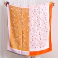 Dettaglio di sciarpa colorata a quadri geometrici con frange fini e morbida trama in cotone - Arancione