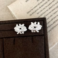 Macro detail of silver woven stud earrings with pavé cubic zirconia on jewelry tray - Silver