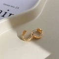 Orecchini a cerchio dorati con texture trapuntata su un vassoio portagioie crema - Orecchini Trapuntati Oro / Oro