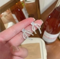 Close-up of silver bow earrings with heart-shaped zircon and lace-textured hollow design - Bowknot Heart Zircon (Silver) / Silver