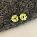 Macro detail of silver twisted knot earrings with bright grass green enamel finish - Green