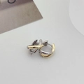 Dettaglio di anelli intrecciati in oro e argento su un orecchino bicolore lucido - Stile Incrociato Oro e Argento