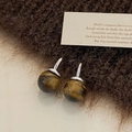Primer plano de pendientes de ojo de tigre esféricos con textura pulida y plata - Pendientes de Ojo de Tigre Plateados