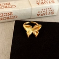 Detail of a matte gold butterfly ring with intricate wing texture on a velvet stand - Gold