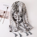 Vue détaillée de l'écharpe bohème en coton et lin avec motifs géométriques et pompons - Gris