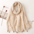 Macro shot of beige linen scarf with golden swallow foil prints and tassel edges - Beige