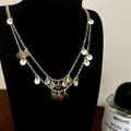Dettaglio della collana a doppio strato con pendenti rotondi lucidi su supporto nero - Collana di paillettes d'oro