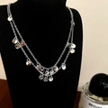 Dettaglio della collana d'argento a due strati con ciondoli a disco lucidi su busto nero - Collana con paillettes d'argento