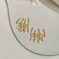 Close-up of golden four-claw ear crawler earrings with cubic zirconia on mirror surface - Four-Row Claw Earrings / Gold