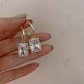 Elegante gouden rechthoekige oorbellen met zirkoon hanger en fonkelende microkristallen - Witte kristallen oorbellen