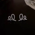 Détail macro de boucles d'oreilles croissant argentées serties de zircons cubiques - Argenté