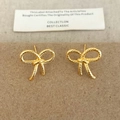 Detailed close-up of golden bow-shaped stud earrings with vintage woven rope texture - Gold