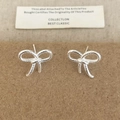 Detailed close-up of silver bow earrings with a twisted rope texture on a craft card - Silver