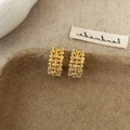 Détail de boucles d'oreilles rectangulaires dorées avec texture martelée sur support - Boucles d'Oreilles Clous Rectangulaires Dorées Texture Martelée / Doré