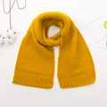 Primer plano de bufanda de punto amarilla para bebé con textura gruesa y borde ondulado - Amarillo jengibre