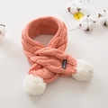 Detail of cable-knit baby scarf in pink-orange with soft white faux fur pom poms - Pink