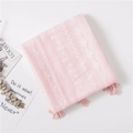 Dettaglio di sciarpa in cotone e lino rosa con ricami bianchi e nappe decorative - Rosa
