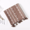 Detail of coffee linen scarf featuring white cross-stitch geometric patterns and fringe - Camel