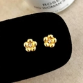 Detailaufnahme goldener Blumenohrstecker mit Zirkonia-Zentren auf schwarzem Samt - Goldene Blumenohrringe (A-642)