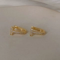Detalle de los pendientes en forma de T dorados con micropavé de circonitas sobre fondo - Aro de Circonita en Forma de T Dorado