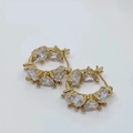 Detalle de pendientes de aro dorados con circonitas en forma de corazón engastadas en garras - Pendientes de corazón / Dorado