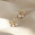 Boucles d'oreilles nœud doré avec perles blanches élégantes sur fond en soie beige doux - Boucles d'Oreilles Perles Noeud / Doré
