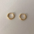 Primer plano de aretes de aro dorados minimalistas con un acabado de espejo pulido brillante - Dorado
