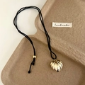 Collar con colgante de corazón dorado texturizado y cordón negro en una bandeja - Dorado