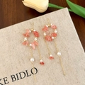 Détail de boucles d'oreilles pampilles en cristal rose et perles blanches sur socle - Boucles d'oreilles à pompon rose