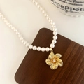 Elegante collana di perle con ciondolo a fiore dorato e cristallo su espositore in legno - Stile Perla Bianca Fiore d'Oro