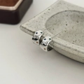 Detail van zilveren ster oorringen met gekleurde zirkoniasteentjes op stenen plateau - Zilver