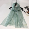 Detail of light green silk wool scarf showing semi-transparent texture and fine rolled edges - 190cm x 90cm / Mint Green