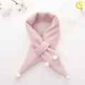 Detail view of pink knitted children's scarf with soft white pom-poms and cross-loop design - Pink
