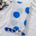 Detail of white cotton linen scarf featuring blue dots, silver accents, and tassel edges - Blue