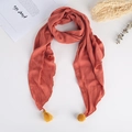 Détail d'une écharpe enfant en lin orange avec glands jaunes et pompons décoratifs - Rouge Orangé