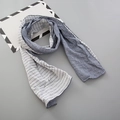 Détail d'une écharpe en coton à rayures bleu-gris montrant les coutures et la texture - Gris clair