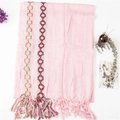 Close-up of pink linen scarf with colorful wave embroidery and tassel fringe edges - Pink