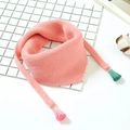 Détail d'une écharpe triangle en tricot rose avec des pompons de couleur vert menthe - Rose