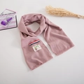 Detail of pink knitted kids scarf featuring a cute bear patch and tricolor ribbon accent - Dusky Pink