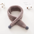 Close-up of soft grey plush fleece toddler scarf with decorative fuzzy balls for winter - Gray