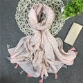 Dettaglio di sciarpa in cotone rosa con pois metallici argento e bordi con frange su stuoia - Rosa