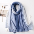 Sciarpa in cotone sfumato blu e bianco con nappe su sfondo bianco minimalista - Gradiente Blu