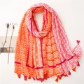 Détail de l'écharpe en coton et lin avec motifs géométriques et pompons - 180x90 / Orange